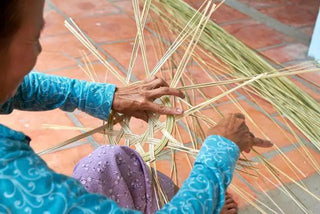 An artisan weaving a panel in an archived Mekong Delta photograph.