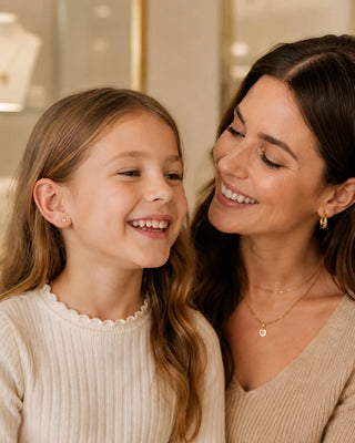 Adult and child smiling together, with small earrings visible