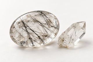 Editorial illustration of quartz with dark needlelike inclusions; inclusion species not identified