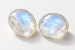 Editorial illustration of milky feldspar cabochons with soft blue sheen