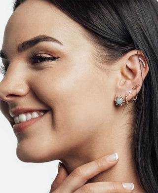 Portrait styling reference showing a blue lobe accent and several ear-jewelry details