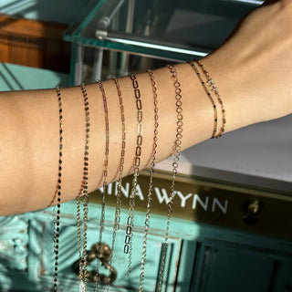 Permanent jewelry chain styles displayed across a forearm at Nina Wynn