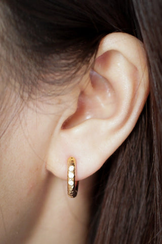 Telletubies 14k gold hoop earrings featuring gold hoop earrings with three small white stones set along the curve