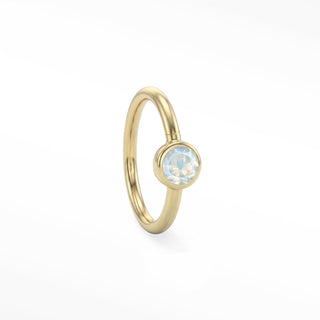 14K yellow gold solitaire seam ring with a round moonstone in a polished bezel setting