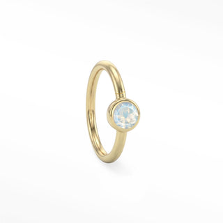 14K yellow gold solitaire seam ring with a round moonstone in a polished bezel setting