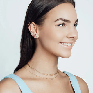 A delicate 14k necklace in forged diamond gold with layered oval links and small dangling beads in rose gold