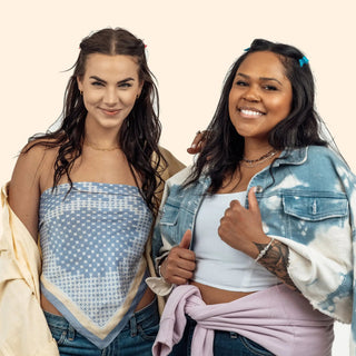 Two women pose for group event booking wearing a blue patterned top and tie-dye denim jacket by jewelry designer nina wynn