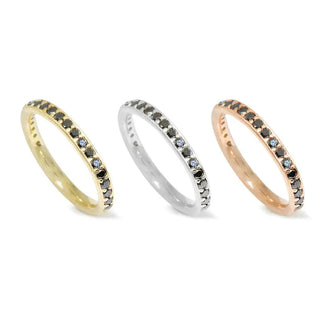 Three elegant eternity bands featuring alternating black diamond 14k and light blue stones in gold, silver, and rose gold