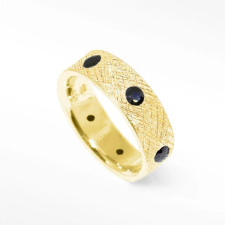 Gold ring with textured surface and three dark blue sapphires from black diamond cigar florentine 14k gold band