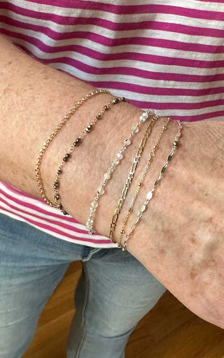 Bold stack of welded permanent bracelets creating a layered infinity jewelry style in Denver.