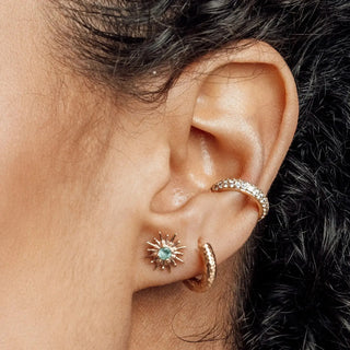 Gold-toned 14k yellow gold cartilage hoop earring and matching star-shaped stud with teal gemstone by nina wynn