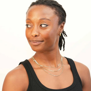 Gold layered necklaces with delicate chain design worn by model for book permanent jewelry nina wynn appointment in denver