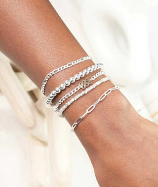 A set of five silver-toned permanent jewelry bracelets with chain links and a script charm book nina wynn appointment in Denver