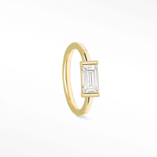 A delicate 14k gold cartilage hoop earring featuring a rectangular emerald-cut clear baguette diamond gemstone