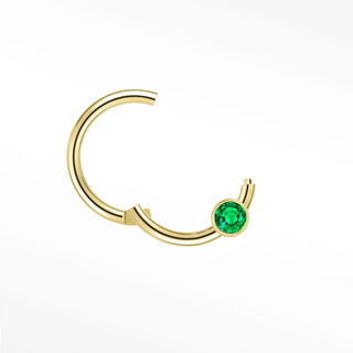 Cartilage hoop earrings in 14k gold with a bezel-set emerald. Display vibrant forest-green glow your ear stack
