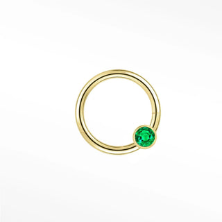 Cartilage hoop earrings in 14k gold with a bezel-set emerald. Display vibrant forest-green glow your ear stack