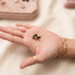 Ear charms crafted in solid 14k gold featuring a faceted green tourmaline briolette drop. Easily slide onto