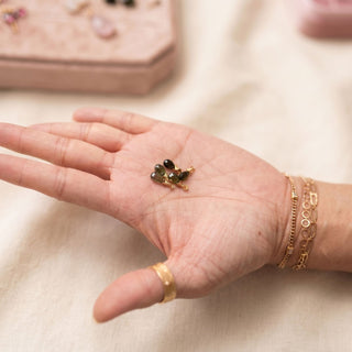 Ear charms crafted in solid 14k gold featuring a faceted green tourmaline briolette drop. Easily slide onto