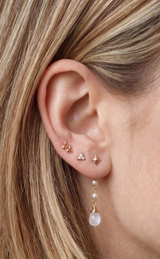 Ear charm crafted in solid 14k gold featuring a beautiful cascade of three natural pearls and faceted moonstone