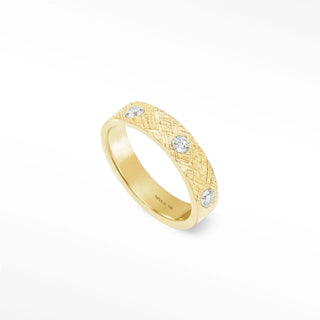 A 14k gold cigar band ring with a textured surface and three round band ring diamonds set along its side