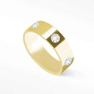 A sleek 14k gold cigar band ring with three round-cut diamonds evenly spaced on its polished surface