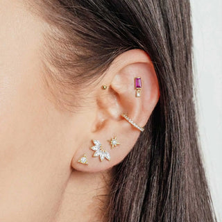 A collection of 14k yellow gold wynning studs flat back earrings with purple gemstones and clear cubic zirconia accents