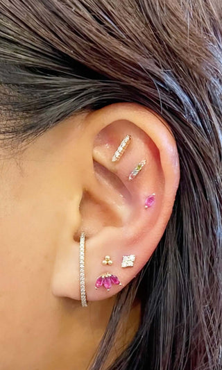 Curated ear piercing with pink gemstone jewelry, helix and lobe piercings styled with fine jewelry on a real client in Denver
