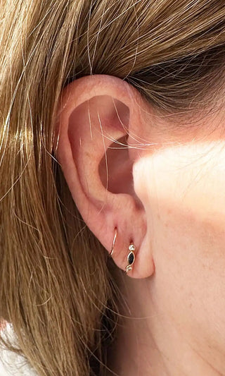 Real client curated ear piercing with multiple piercings and fine jewelry in Denver studio