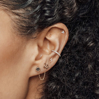 A delicate rose gold lightning bolt earring with a pave diamond finish.