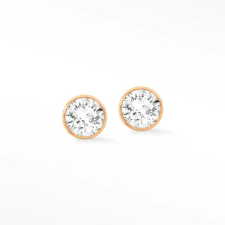 Bezel diamond stud earrings in 14k rose gold featuring round clear faceted gemstones in a rose gold setting