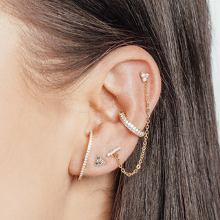 Gold-toned ear cuff with clear crystals and delicate chain designed by jewelry designer nina wynn for ear spa Denver