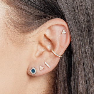A delicate gold-toned ear cuff with sparkling clear stones by jewelry designer nina wynn at ear spa denver