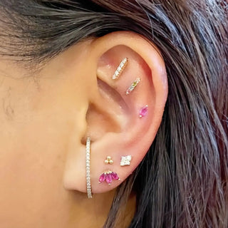 A delicate gold-toned ear cuff with clear crystals designed by nina wynn at ear spa denver jewelry designer