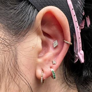 Gold-toned ear piercing with square pave-set diamond design by jewelry designer nina wynn at ear spa denver