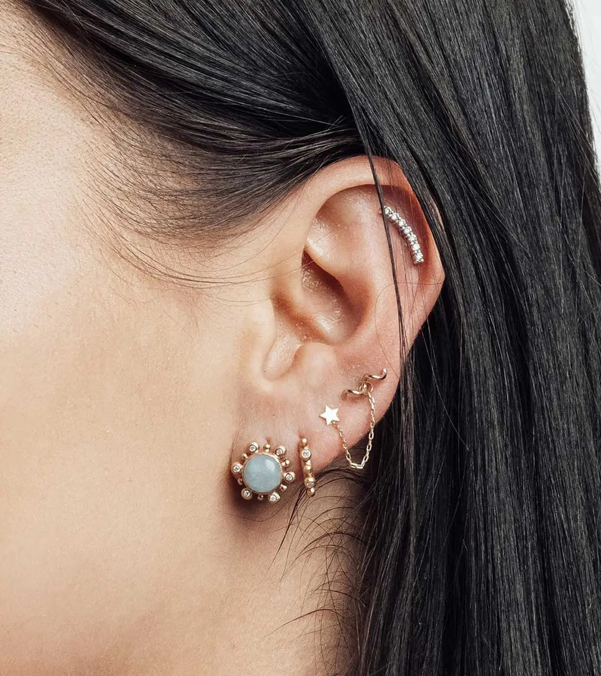 Ear styled with multiple pieces of fine piercing jewelry