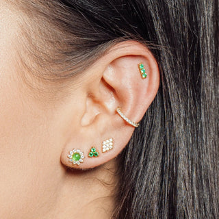 A set of gold 14k earrings with flat backs featuring green gemstones and clear crystals from the wynning studs collection