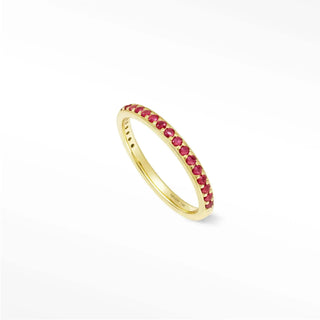A delicate gold band ruby eternity ring featuring vibrant red rubies in thea 14k gold setting