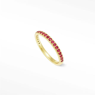A delicate gold band ruby eternity ring featuring vibrant red rubies in thea 14k gold setting