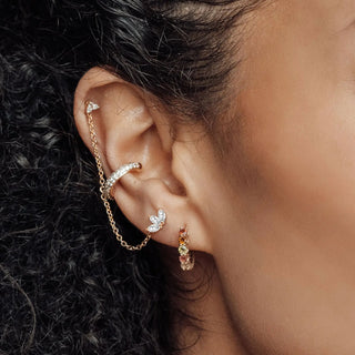 A delicate gold-toned 14k moissanite earrings ear cuff with baby lotus butterfly and matching chain from wynning studs