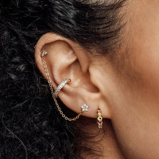 Gold-toned flat back 14k yellow ear cuff with diamond daisy flower stud connected by delicate chain by the wynning studs