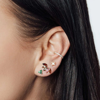 A delicate rose gold ear cuff with sparkling pavé stones complementing 14k yellow moonstone earrings wynning studs