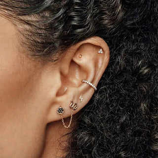 Rose gold hoop earring with delicate chain and black gemstone accent suitable as cartilage earring lightning bolt design