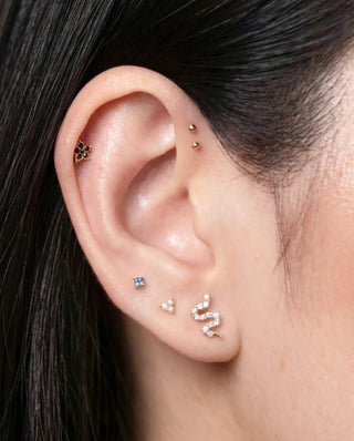 Gemstone earrings styled on an ear with other studs and hoops, view 2