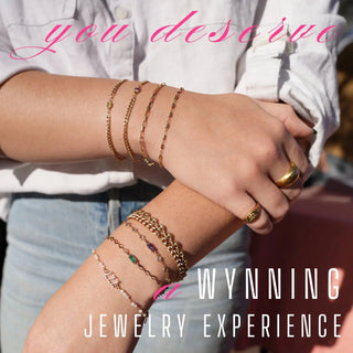 A collection of gold-toned chain link bracelets with gemstone accents worn on wrists for the wynning jewelry experience denver