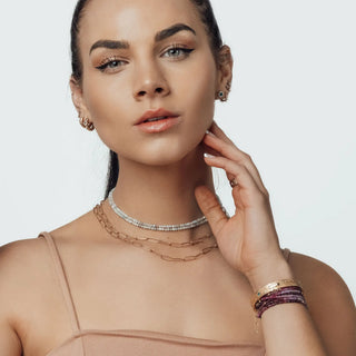 Gold chain necklace with a delicate, beaded design.