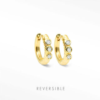 Telletubies gold hoop earrings featuring four clear round stones set along the outer curve in a reversible design