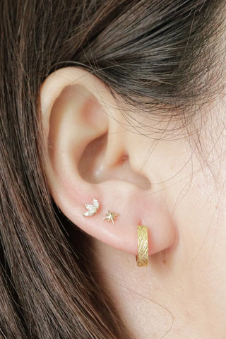 Gold textured Florentine huggie earrings by Wynning featuring a reversible hoop design for versatile wear