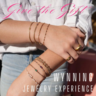 A collection of gold-toned bespoke jewelry bracelets with chain links and gemstone accents for a jewelry experience gift