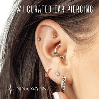 Gold-toned ear piercing set with green gemstone hoop and varied studs for bespoke jewelry experience gift