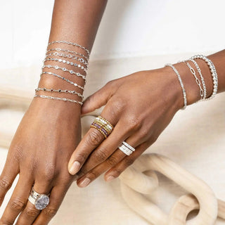 Stacked silver rings with a central druzy stone and pave-set diamonds worn on the index finger at a jewelry shopping appointment